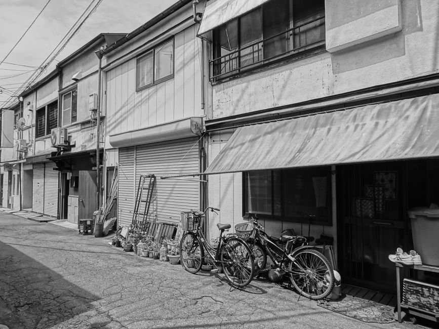 Small Japanese port town street in Setoda with old shops and bicycles parked outside